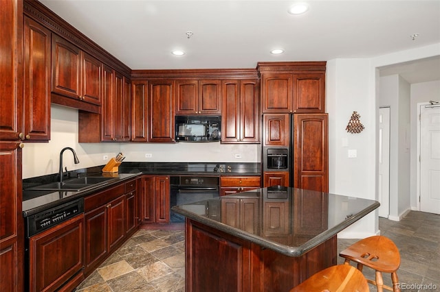 kitchen with a breakfast bar, a sink, a center island, black appliances, and dark countertops