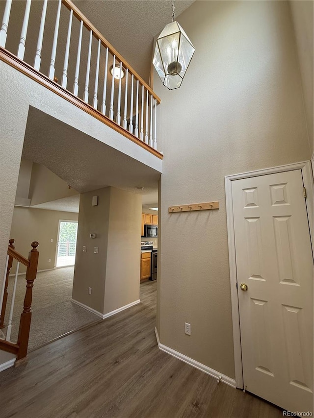 23760 Broadmoor Dr, Parker, CO 80138 - staircase featuring wood finished floors, baseboards, and a high ceiling