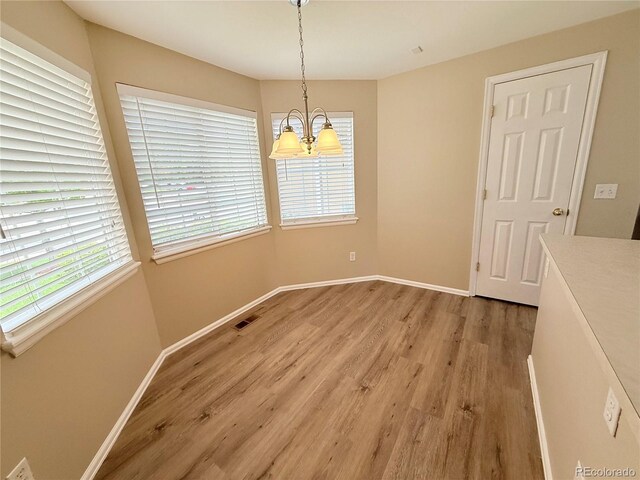 23760 Broadmoor Dr, Parker, CO 80138 - unfurnished dining area with a chandelier, light wood-style flooring, and plenty of natural light
