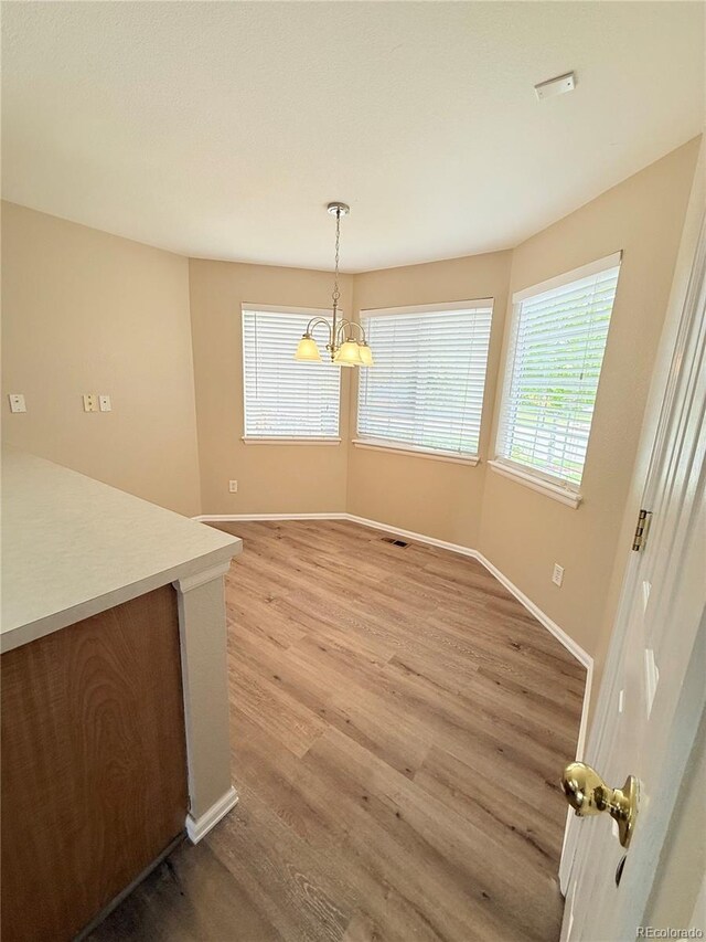 23760 Broadmoor Dr, Parker, CO 80138 - unfurnished dining area featuring light wood-style floors, baseboards, and a chandelier