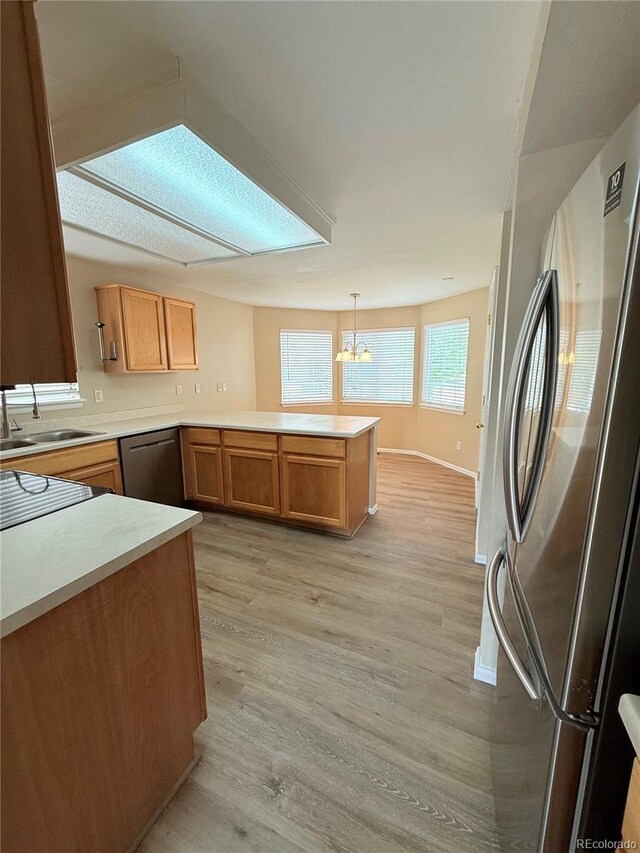23760 Broadmoor Dr, Parker, CO 80138 - kitchen featuring stainless steel appliances, a sink, a peninsula, light wood-style floors, and a chandelier