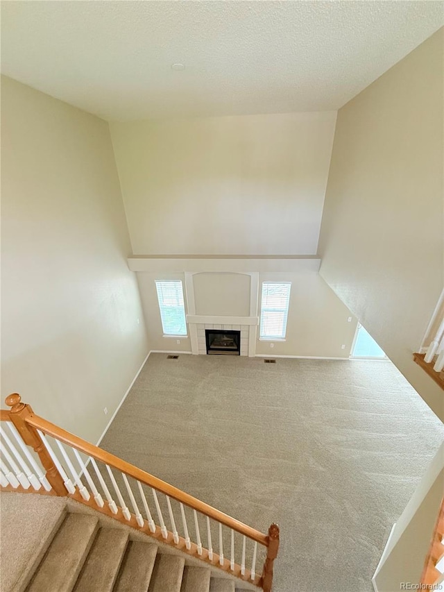 23760 Broadmoor Dr, Parker, CO 80138 - stairway featuring carpet flooring, a tiled fireplace, and baseboards