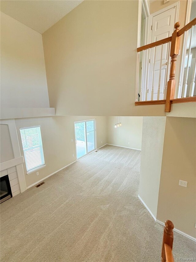 23760 Broadmoor Dr, Parker, CO 80138 - unfurnished living room featuring carpet flooring, baseboards, a fireplace, and lofted ceiling