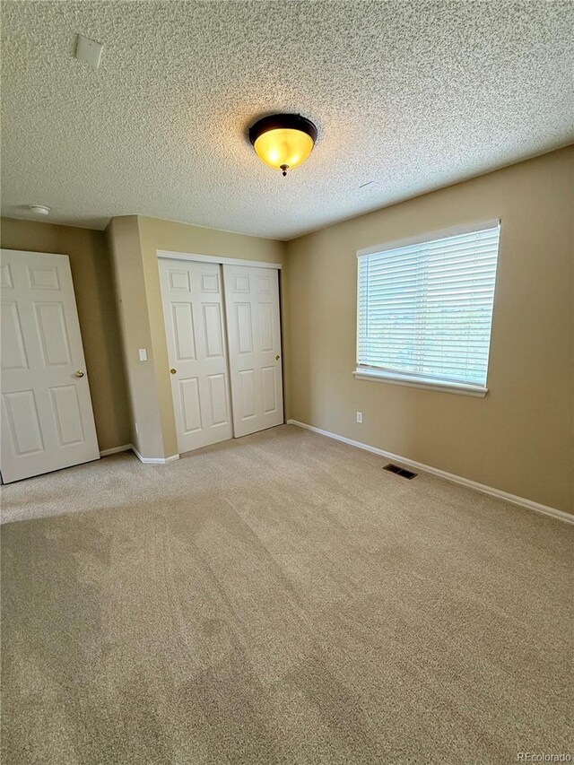 23760 Broadmoor Dr, Parker, CO 80138 - unfurnished bedroom with a closet, carpet floors, baseboards, and a textured ceiling