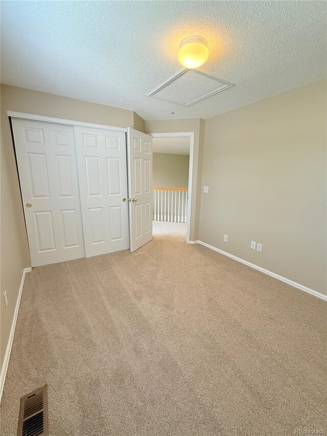 23760 Broadmoor Dr, Parker, CO 80138 - unfurnished bedroom featuring a closet, light colored carpet, a textured ceiling, and baseboards