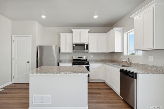 kitchen featuring sink, light hardwood / wood-style flooring, appliances with stainless steel finishes, and a center island