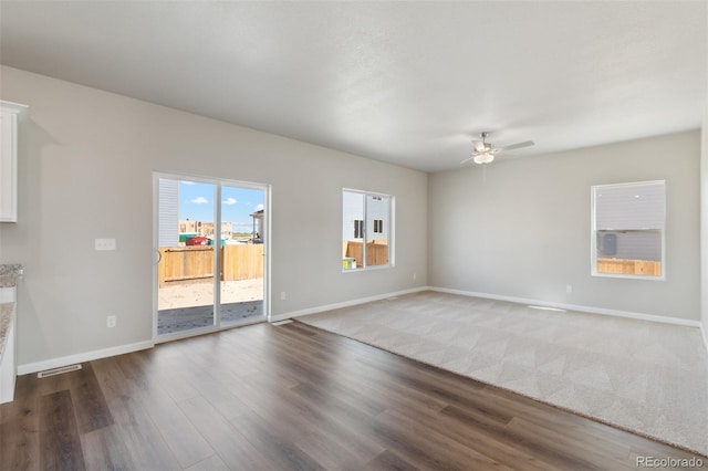 unfurnished living room featuring wood finished floors, a ceiling fan, baseboards, and visible vents