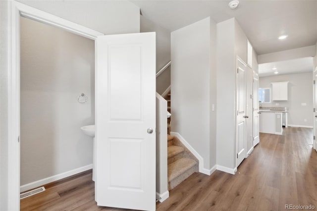 stairs featuring recessed lighting, visible vents, baseboards, and wood finished floors