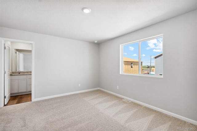 unfurnished bedroom featuring carpet flooring, visible vents, and baseboards