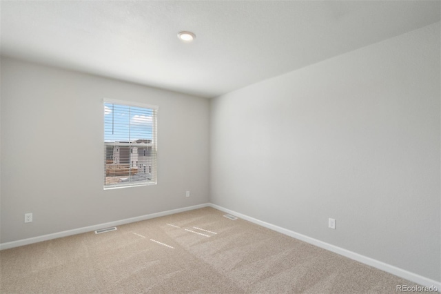 unfurnished room with visible vents, carpet floors, and baseboards