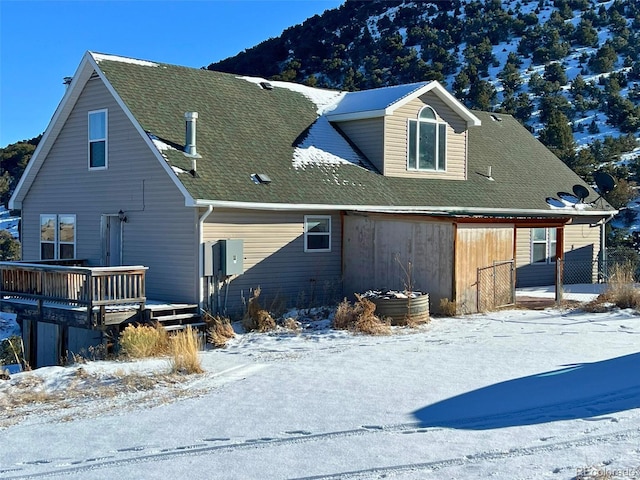 snow covered property with a deck