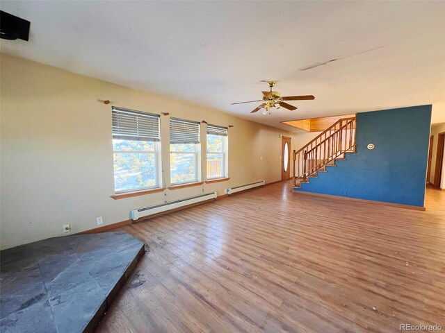 unfurnished living room featuring baseboard heating, ceiling fan, and hardwood / wood-style flooring