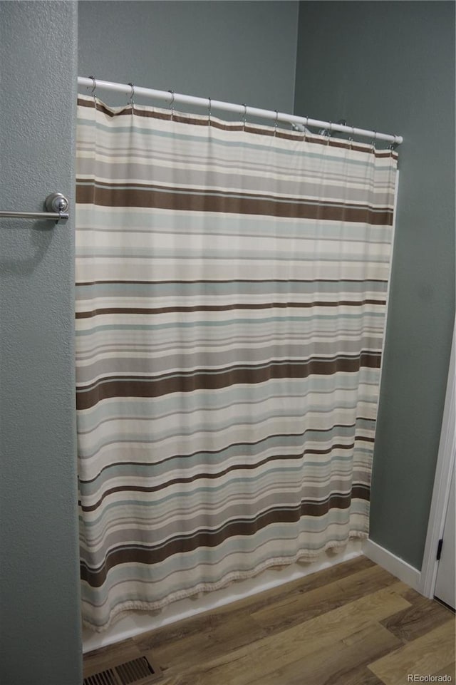179 13th Ave, Cedaredge, CO 81413 - bathroom with curtained shower, visible vents, a textured wall, and wood finished floors