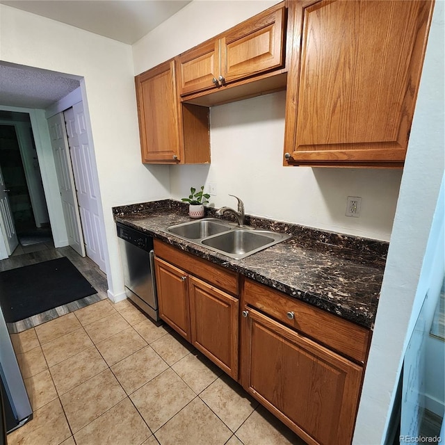 384 S Ironton St Unit 102, Aurora, CO 80012 - kitchen with stainless steel dishwasher, brown cabinetry, and light tile patterned floors
