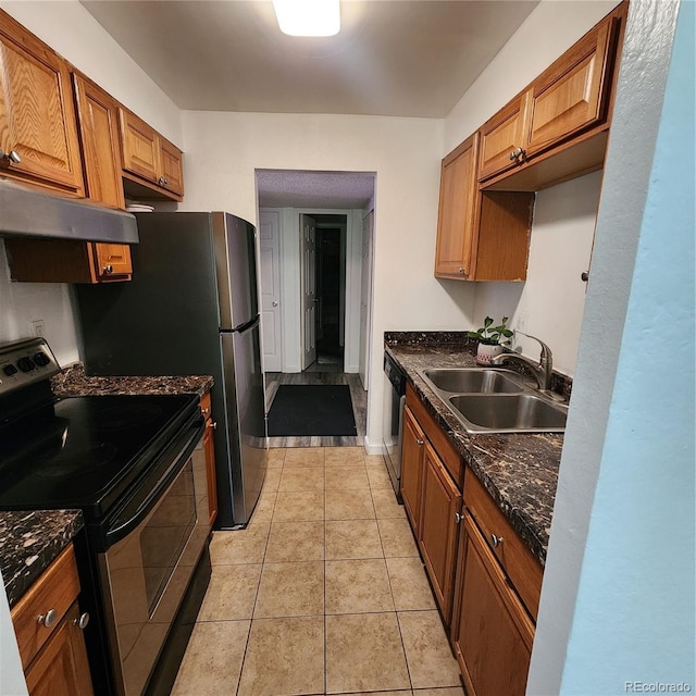 384 S Ironton St Unit 102, Aurora, CO 80012 - kitchen featuring appliances with stainless steel finishes, dark countertops, under cabinet range hood, brown cabinetry, and light tile patterned floors