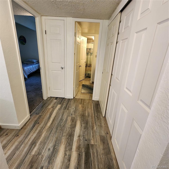 384 S Ironton St Unit 102, Aurora, CO 80012 - hallway featuring dark wood-style flooring and a textured ceiling