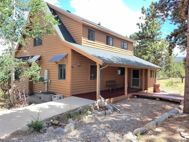 back of property featuring a wooden deck, faux log siding, and a shingled roof