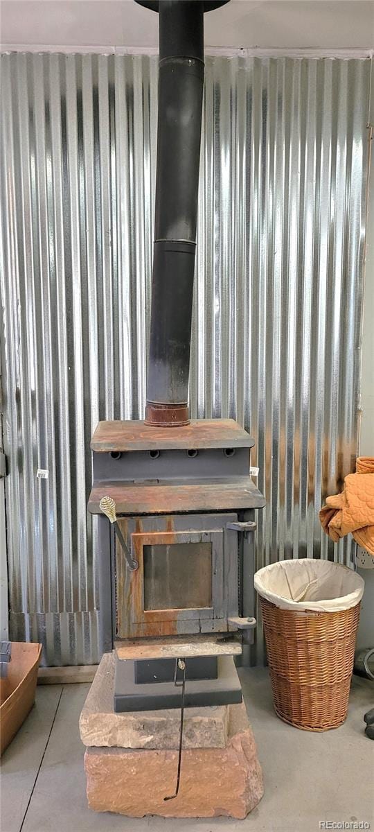 interior details with concrete floors and a wood stove