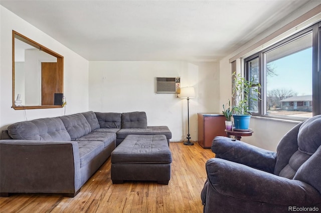 living room featuring light wood-type flooring and a wall mounted AC