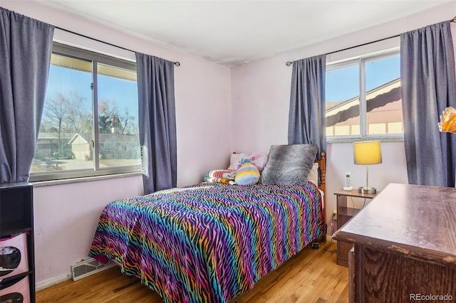 bedroom featuring light wood-type flooring and multiple windows