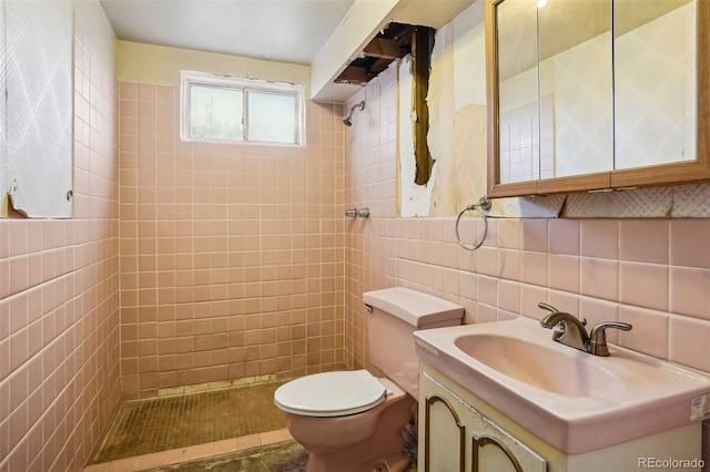 bathroom with vanity, a tile shower, tile walls, and tasteful backsplash