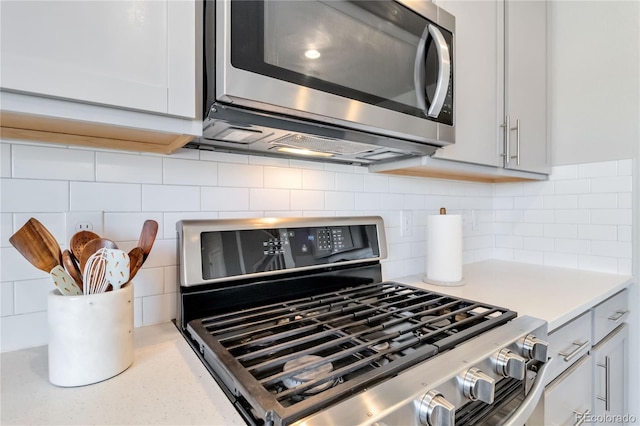 kitchen with decorative backsplash, light countertops, and stainless steel appliances