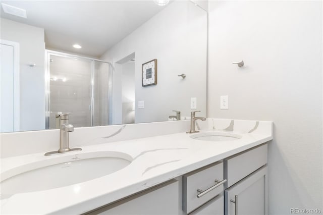 full bathroom with double vanity, recessed lighting, a shower stall, and a sink