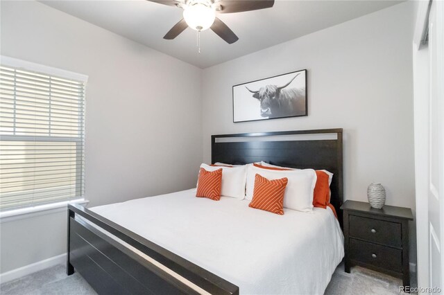 bedroom featuring light carpet, baseboards, and a ceiling fan