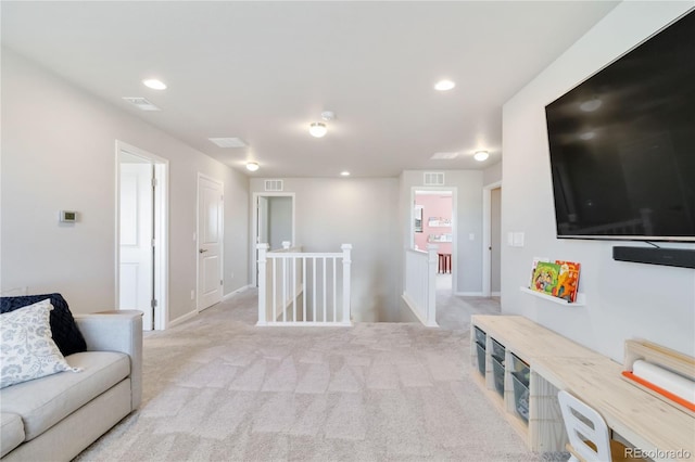 living area with light carpet, visible vents, and recessed lighting