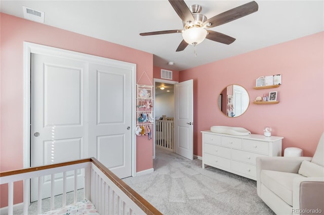 bedroom with light colored carpet, visible vents, a closet, and ceiling fan