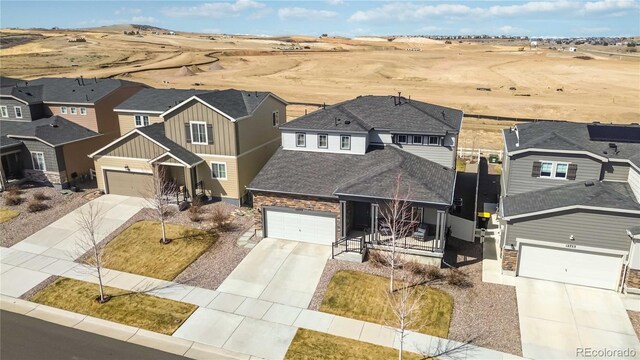 view of front of property featuring a residential view, board and batten siding, roof with shingles, concrete driveway, and a garage