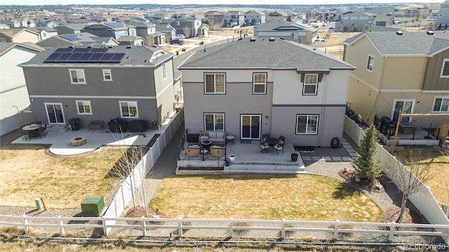 rear view of property featuring a fenced front yard, a residential view, central AC, stucco siding, and a patio