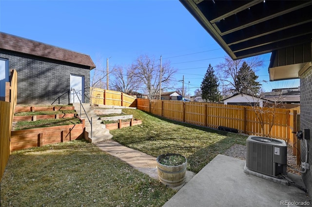 view of yard featuring cooling unit, a garden, and a fenced backyard