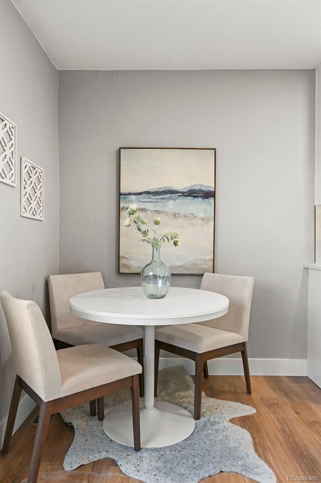 dining room featuring baseboards and wood finished floors