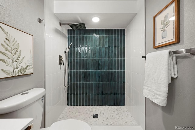 full bath with toilet, a tile shower, and vanity