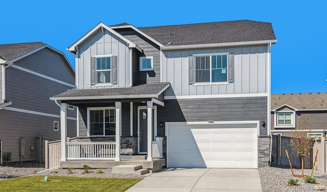 view of front facade featuring covered porch, concrete driveway, board and batten siding, a garage, and stone siding