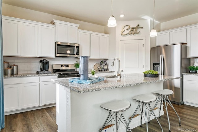 kitchen featuring appliances with stainless steel finishes, dark wood-style flooring, and backsplash