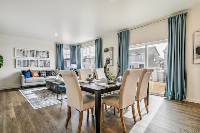 dining space featuring wood finished floors and baseboards