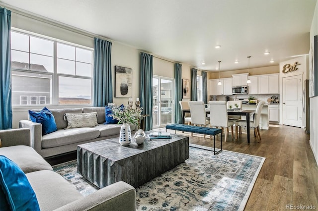 living room with dark wood-style flooring, plenty of natural light, and recessed lighting