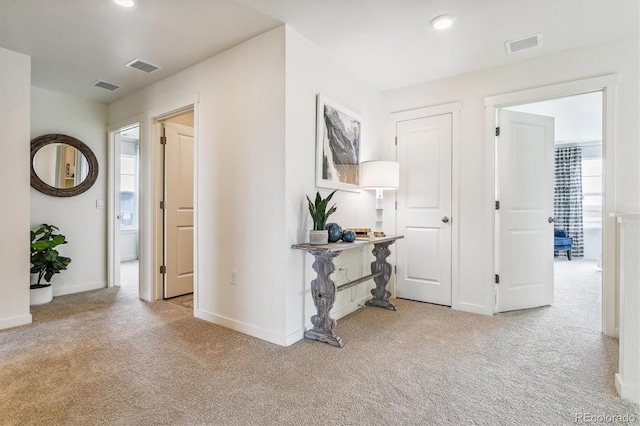 hall featuring recessed lighting, carpet flooring, and visible vents