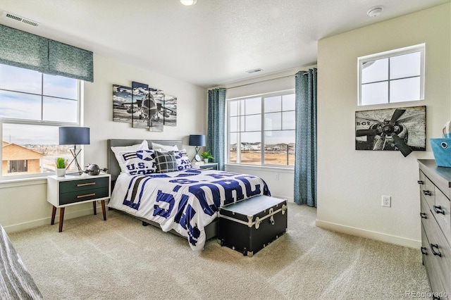 carpeted bedroom featuring a textured ceiling, visible vents, and baseboards