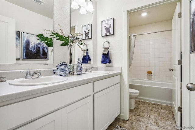 full bath featuring double vanity, shower / tub combo, a sink, and toilet