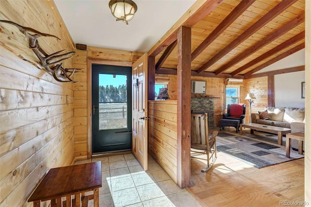 doorway featuring lofted ceiling with beams, wood walls, light hardwood / wood-style flooring, and wood ceiling