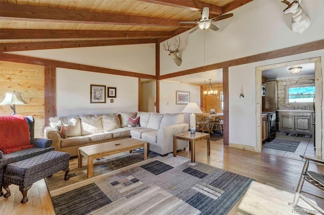 living room featuring wood ceiling, ceiling fan with notable chandelier, wooden walls, beam ceiling, and hardwood / wood-style flooring