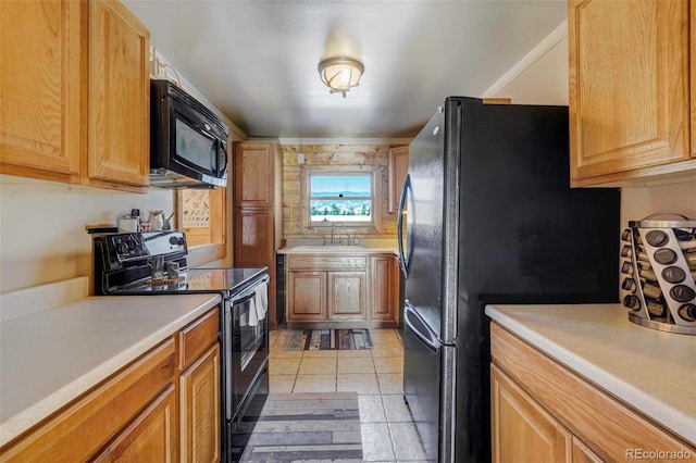 kitchen with black appliances, light tile patterned floors, and sink