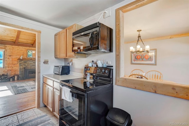 kitchen with light brown cabinets, light wood-type flooring, pendant lighting, and black appliances