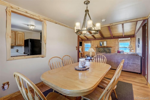 dining space featuring wood ceiling, a healthy amount of sunlight, a notable chandelier, and light hardwood / wood-style floors