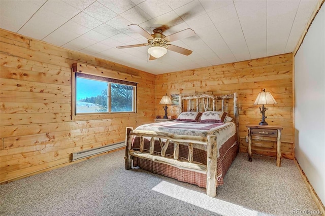 bedroom with carpet flooring, ceiling fan, wooden walls, and a baseboard radiator