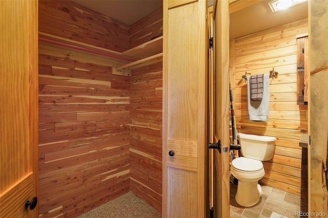 bathroom with wooden walls and toilet