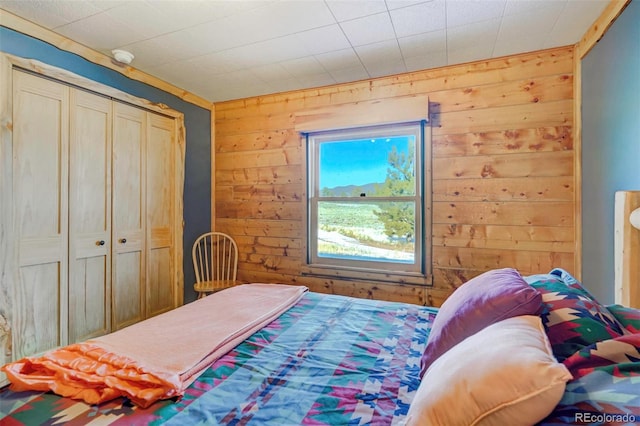 bedroom with wood walls and a closet